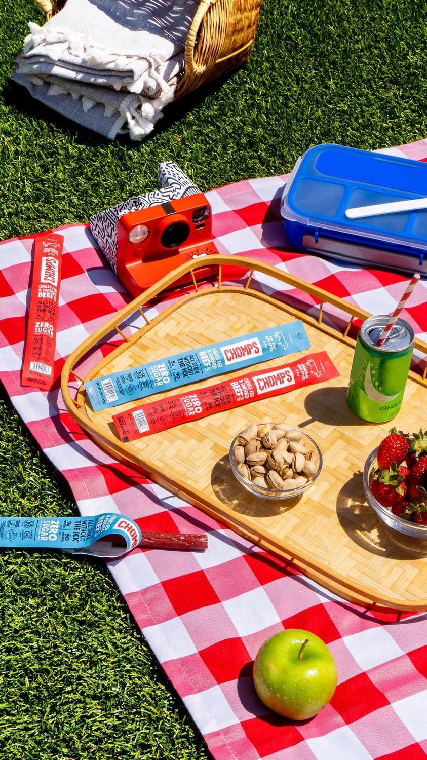Beef stick snacks styled on a picnic tray with fruit