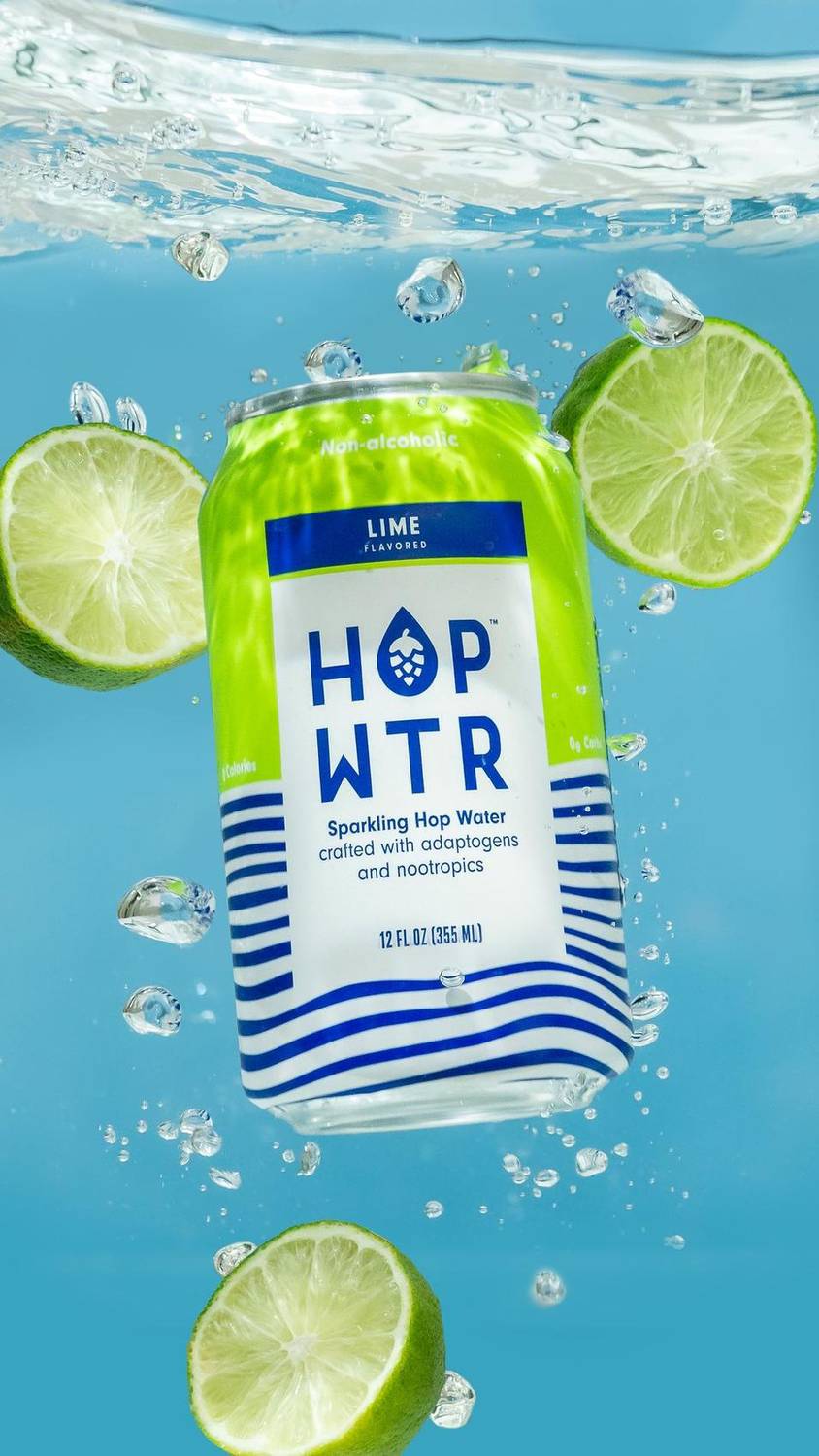 Lime-flavored sparkling hop water can submerged in water with limes
